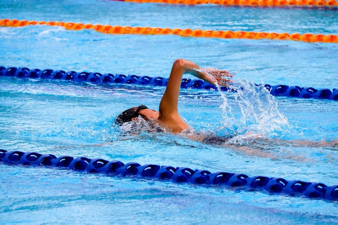 Schwimmerin zieht Bahnen im sonnigen Freibad